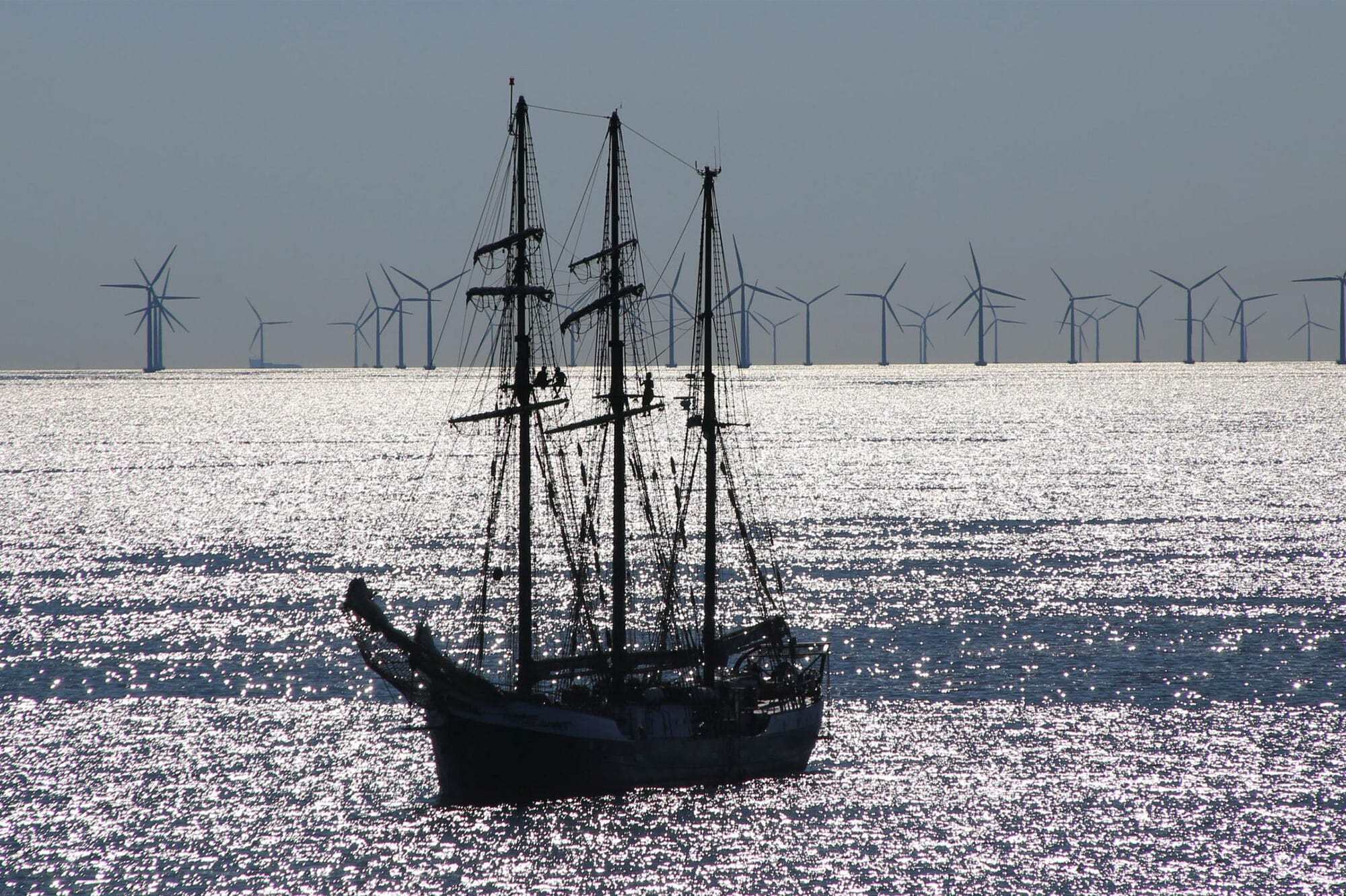 Schiff auf See, Windräder im Hintergrund